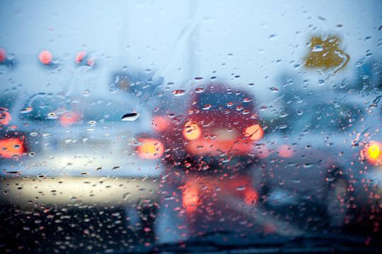 汽車在暴雨中行駛，紅燈模糊
