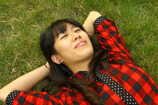 亞洲女人睡在草地上，很放松
