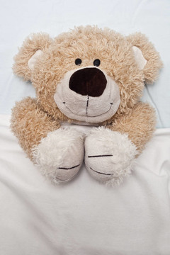 Teddy Bear Laying在床上