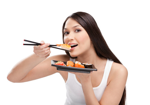 有魅力的女人用筷子吃壽司