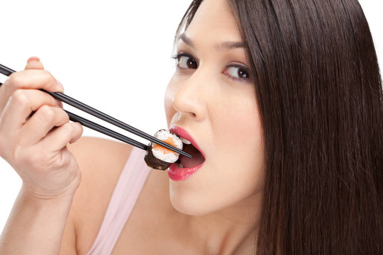 黑發(fā)女子用筷子拿壽司