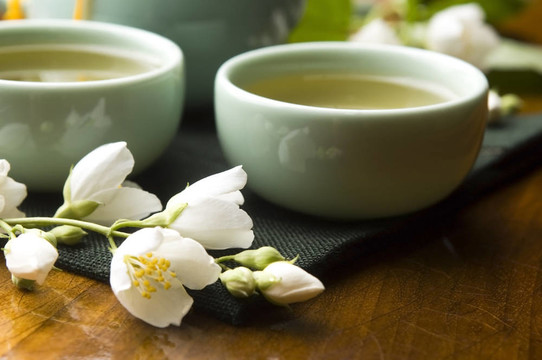 茶幾上的茉莉花茶和木制桌子上的茶壺