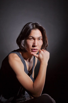 一個(gè)英俊的亞洲肌肉男子在黑色T恤
