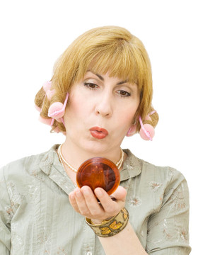 金發(fā)女人用卷發(fā)器看著鏡子