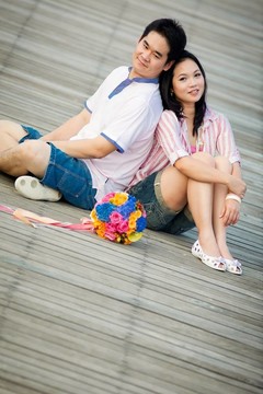 浪漫夫婦坐在木制碼頭上的肖像