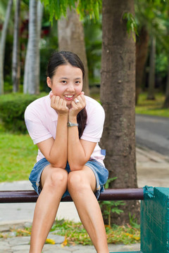 亞洲女子坐在長(zhǎng)椅上微笑