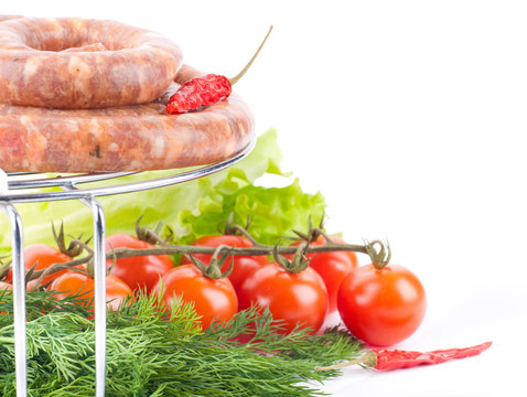 烤架上的豬肉和牛肉香腸；西紅柿；沙拉和香料