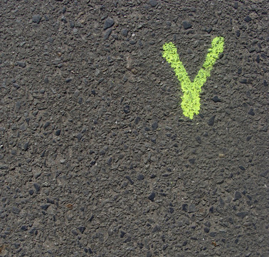 灰色混凝土道路上的熒光黃字體v或Y