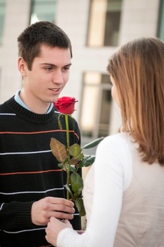 年輕人交出一朵花給女人