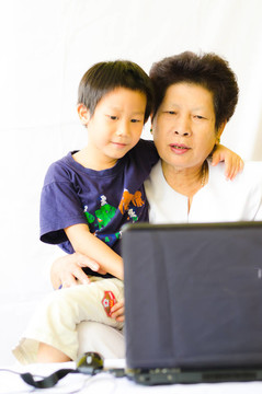 老婦人與男孩使用筆記本電腦