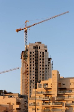 日落時吊裝起重機和正在施工的建筑物