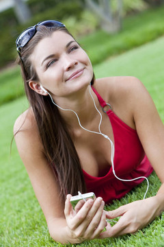美麗的黑發(fā)女人躺下來聽MP3播放器