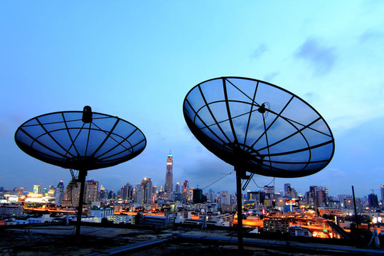 黑色天線通信衛(wèi)星天線在城市日落的天空