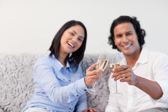 夫婦在沙發(fā)上用起泡酒慶祝