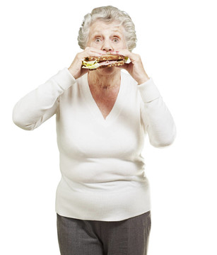 高级女人吃健康的三明治在白色背景
