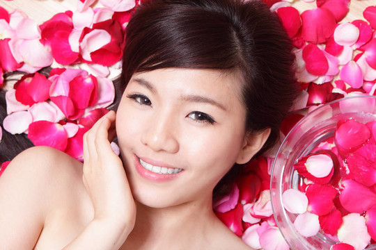 女孩微笑著面對玫瑰
