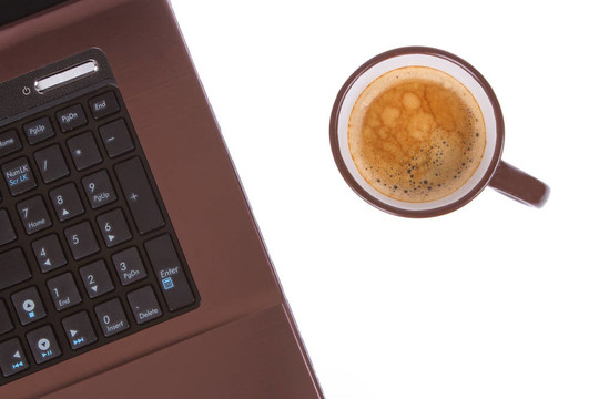 筆記本電腦附近的咖啡杯