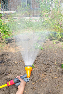 用軟管給花園澆水