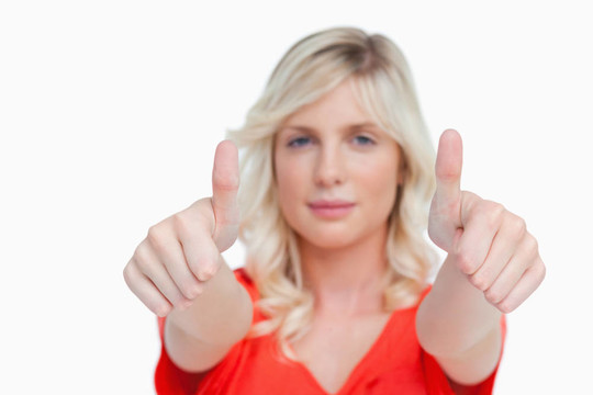 一個(gè)年輕漂亮的女人展示了兩個(gè)大拇指