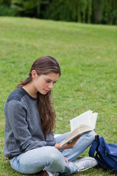 年輕女子一邊看書一邊交叉雙腿