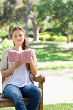 在公園長(zhǎng)椅上看書的女人