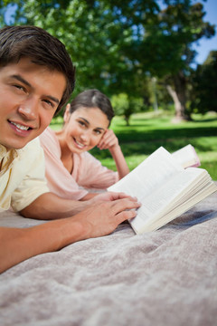 兩個朋友一邊看一邊在公園里看書