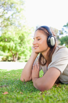 一個女人在草坪上欣賞音樂的側(cè)面