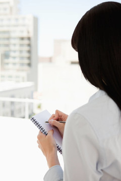 一個(gè)女人開始在她的記事本上寫下