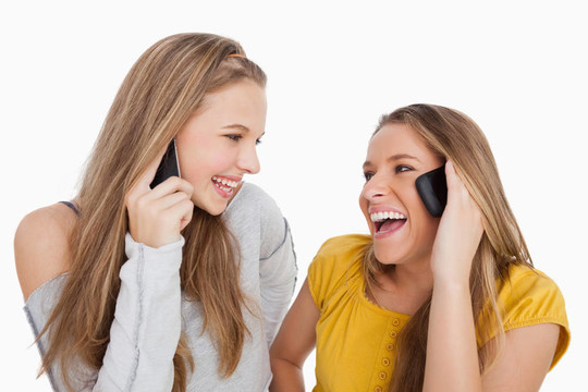 兩個年輕女子在電話上笑起來