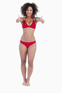 微笑的女人把她的大拇指在海灘