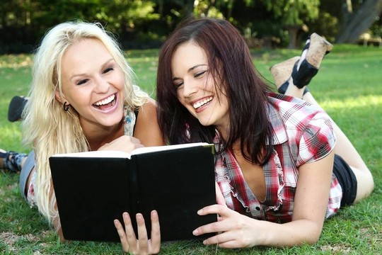 美丽的年轻女性朋友户外阅读