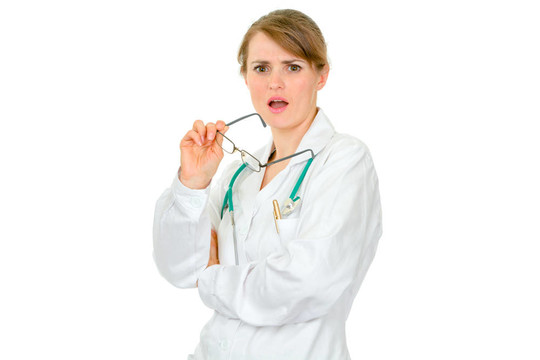 震驚的年輕女醫(yī)生牽著她的手孤立在白色眼鏡