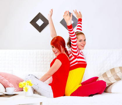 兩個(gè)漂亮的女朋友坐在沙發(fā)上背著