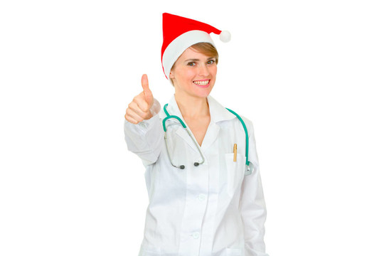 微笑的醫(yī)學(xué)女醫(yī)生在Santa帽子豎起大拇指