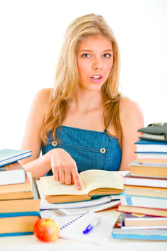 好奇的女孩坐在桌子上指著書