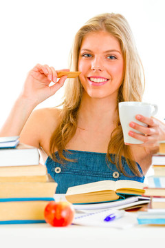面帶微笑的少女坐在桌旁看書，喝茶