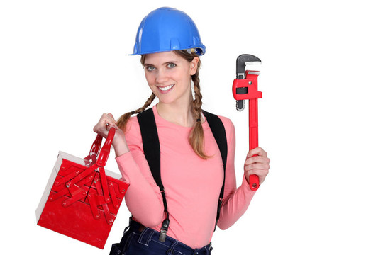 一個(gè)用扳手和工具箱女建筑工人。