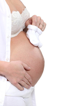 懷孕的婦女抱著嬰兒鞋