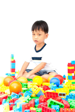 在白色背景上玩玩具的小男孩