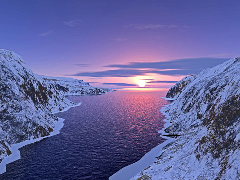 夕陽下雪山間的河流
