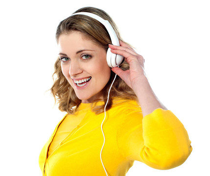 美麗的年輕女子與耳機聽音樂