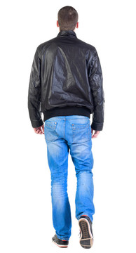 背部行走的英俊男子在夾克。