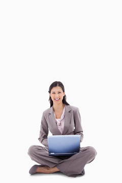 微笑的女人坐在筆記本電腦上