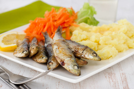 炒沙丁油魚沙拉和土豆泥板上