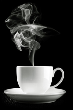咖啡杯在桌子上反對黑色背景
