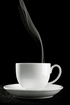 咖啡杯在桌子上反對黑色背景