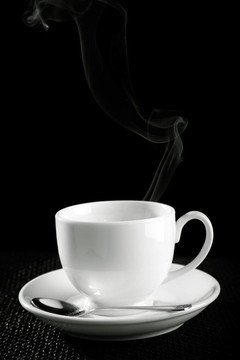 咖啡杯在桌子上反對黑色背景