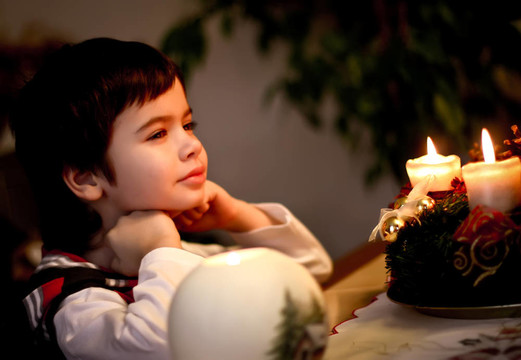 圣誕前夜男孩坐在蠟燭前。圣誕節(jié)。