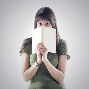 女人躲在書后面。封面是空白的