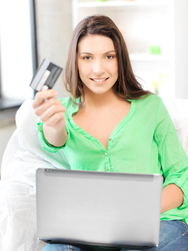 快樂的女人與筆記本電腦和信用卡